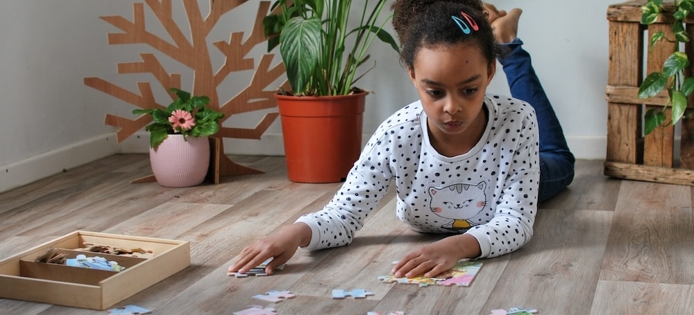 Girl laying on floor putting together a puzzle